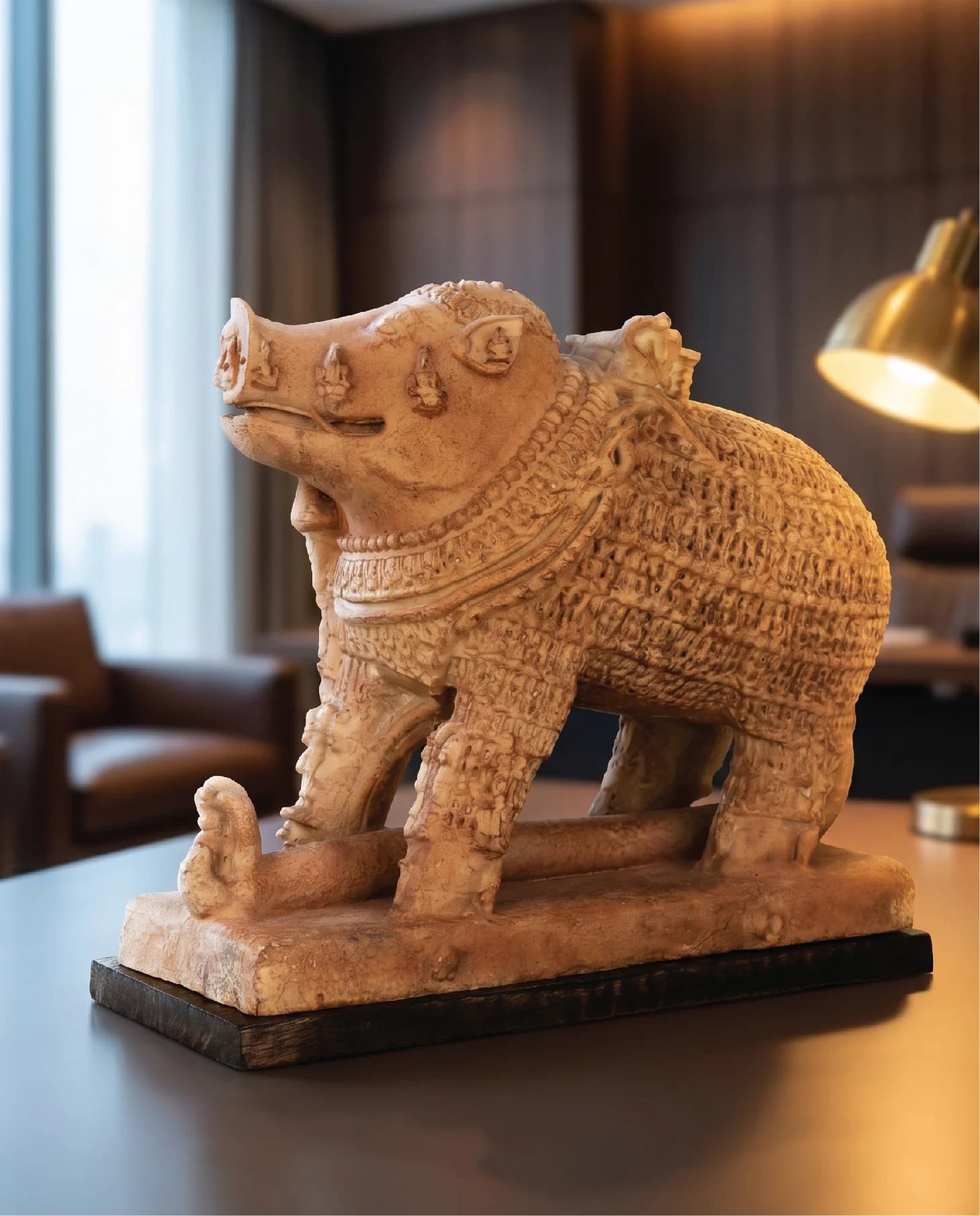 A detailed side view of the Adi Varaha Sculpture, a sandstone-textured replica showing intricate carvings of the boar deity.