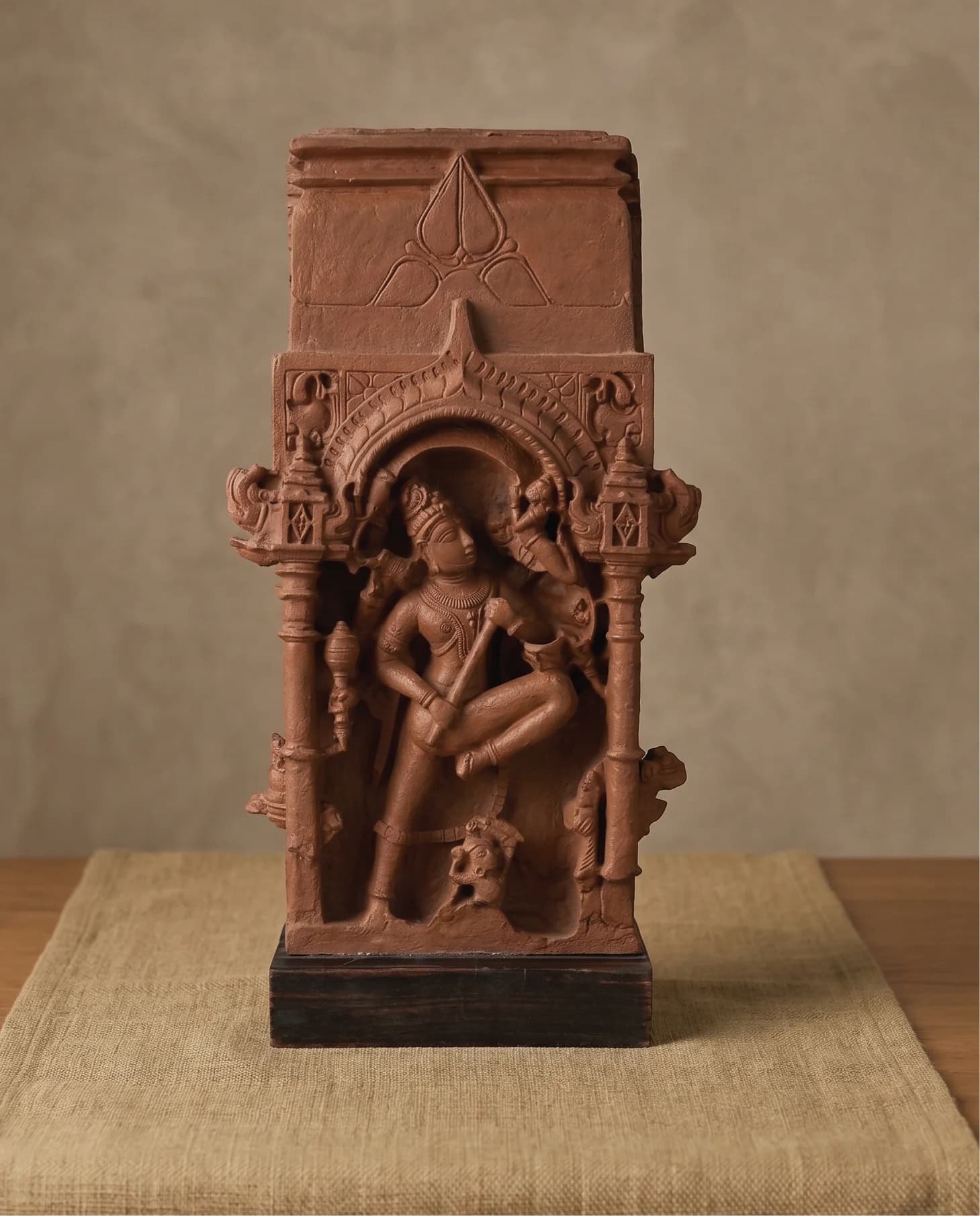 A front-facing view of the Gajasura Vadha Sculpture, a stone composite replica featuring intricate temple relief carvings of Shiva.
