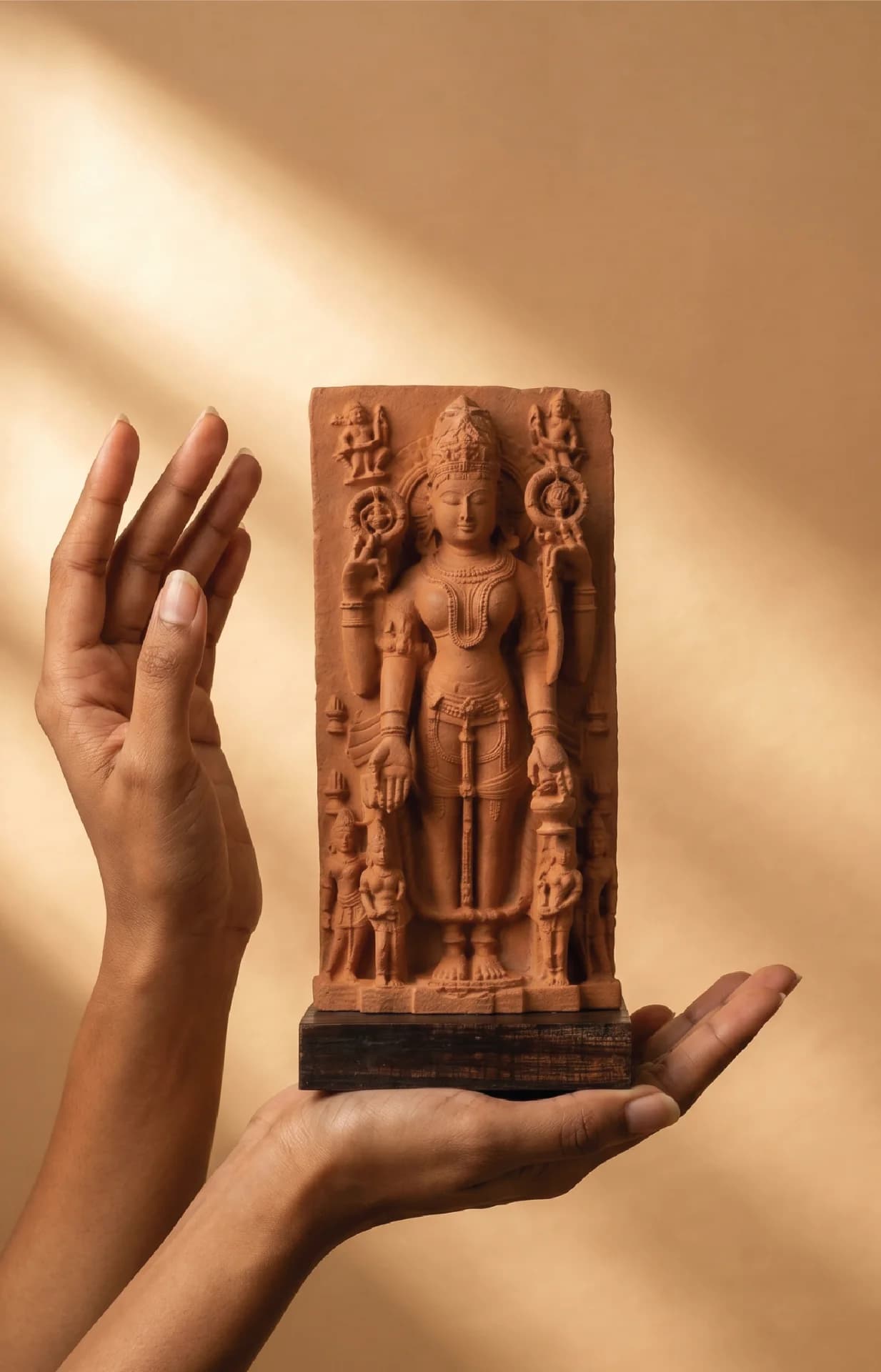 A person's hands gently cradle the Gauri Parvati Sculpture, a detailed stone composite replica of a 10th-century Hindu goddess.