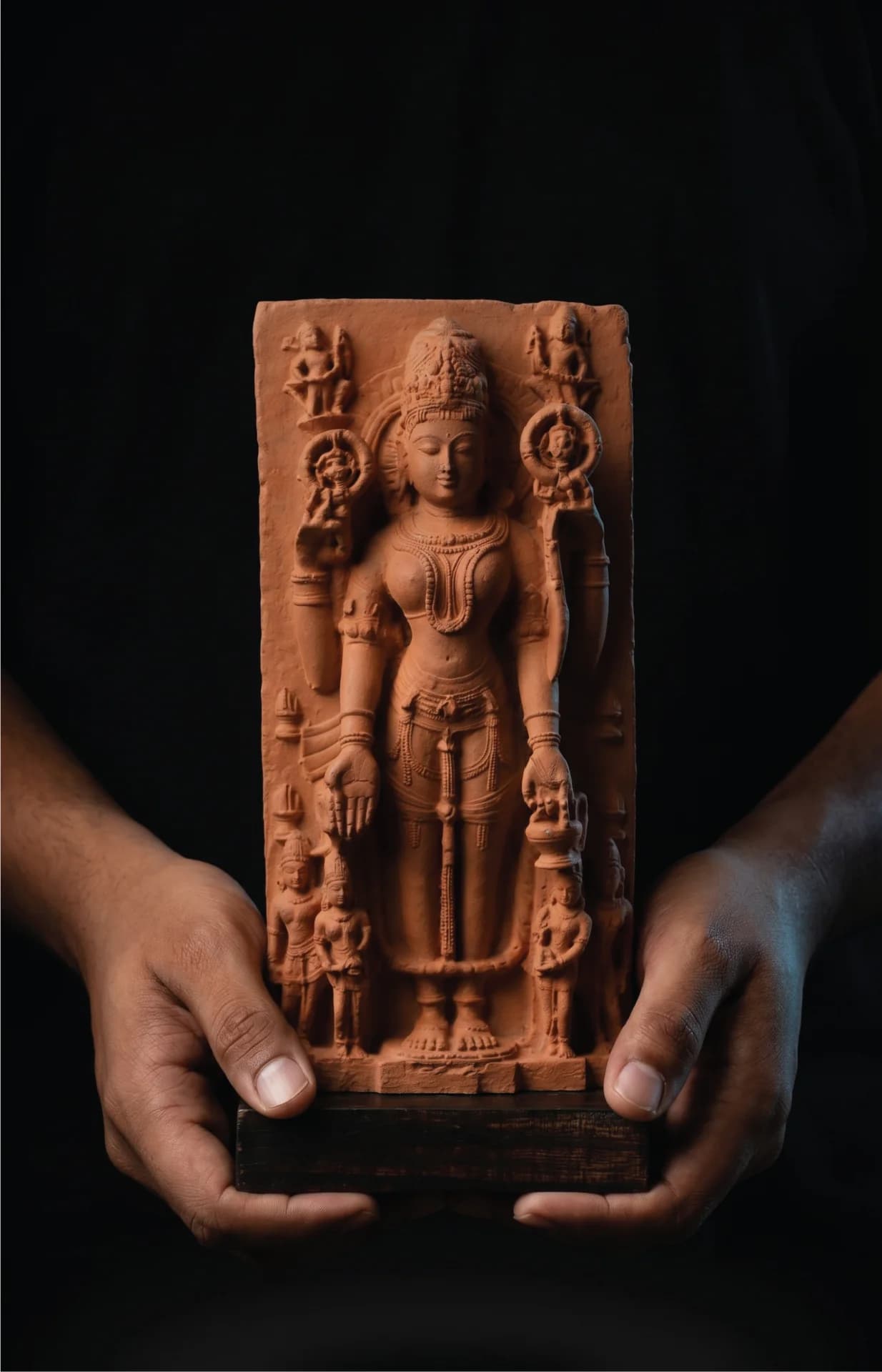 A pair of hands holding a Gauri Parvati Sculpture, a detailed stone composite replica of 10th-century Pratihara temple art.