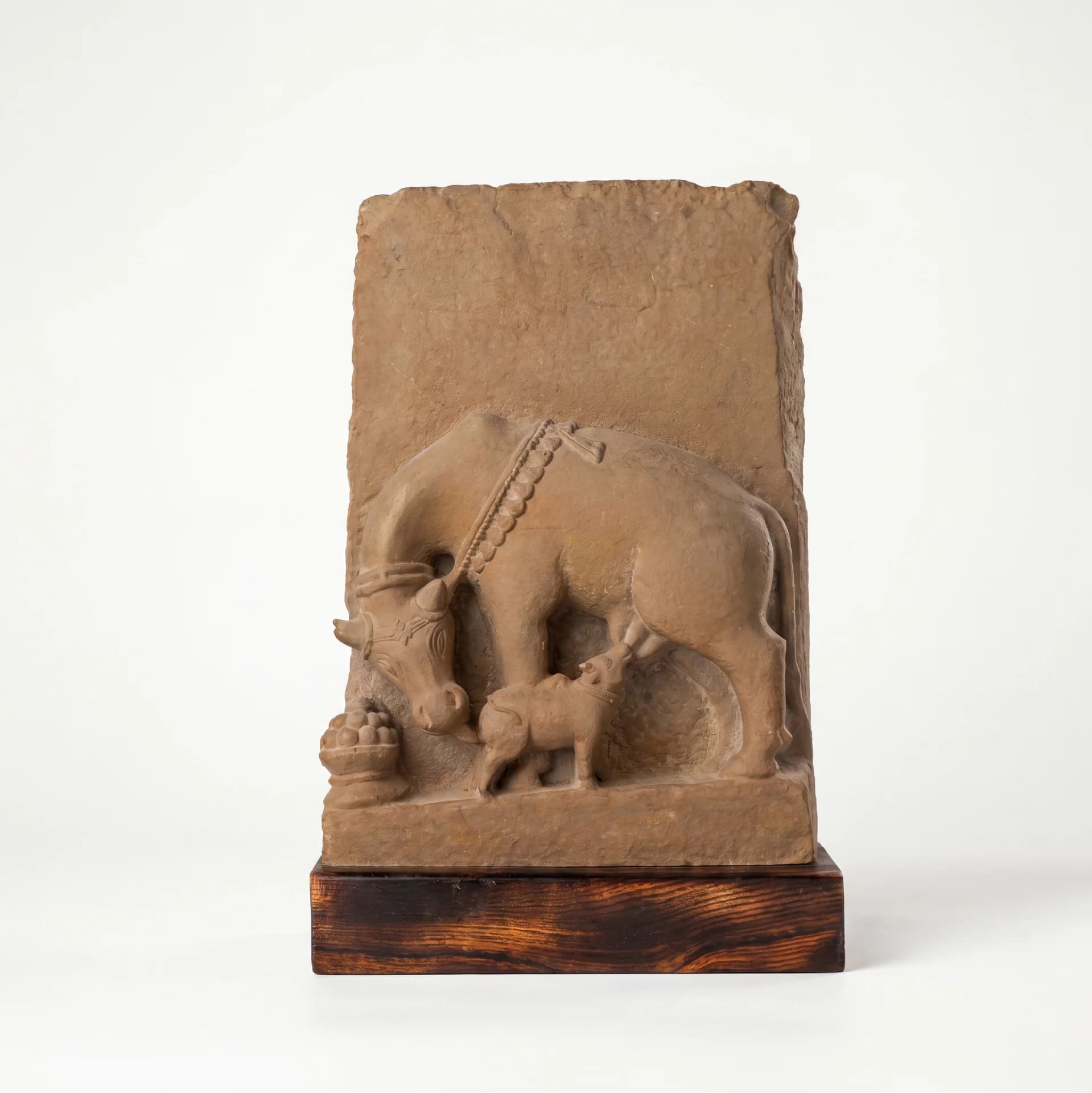 A front-facing view of the Kamdhenu Sculpture, a hand-finished stone composite replica depicting a cow nursing her calf.