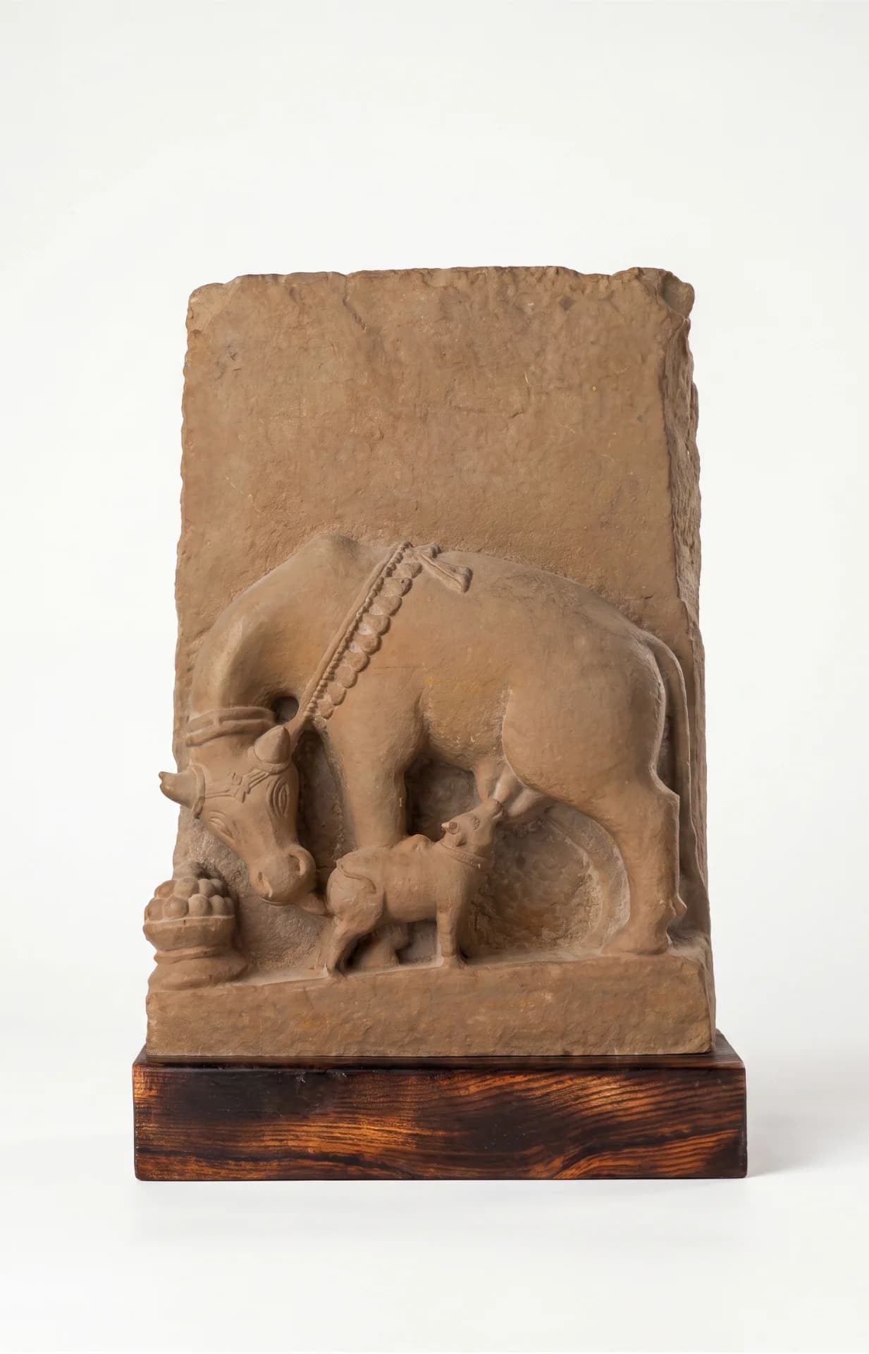 A full front view of the Kamdhenu Sculpture, a hand-finished stone composite replica showing a cow nursing her calf.