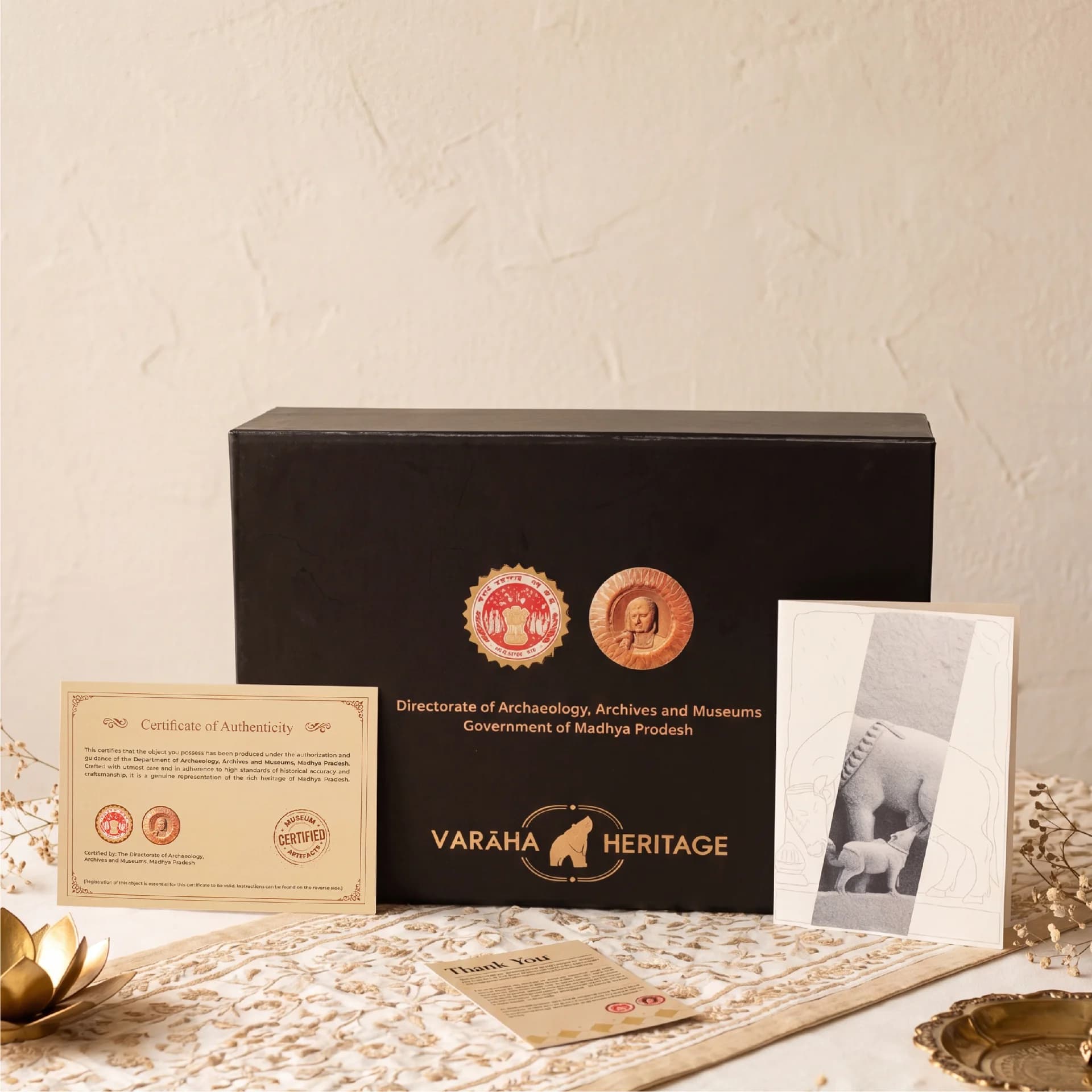 The Kamdhenu Sculpture packaging set includes a black presentation box, a certificate of authenticity, and an illustrated information card.