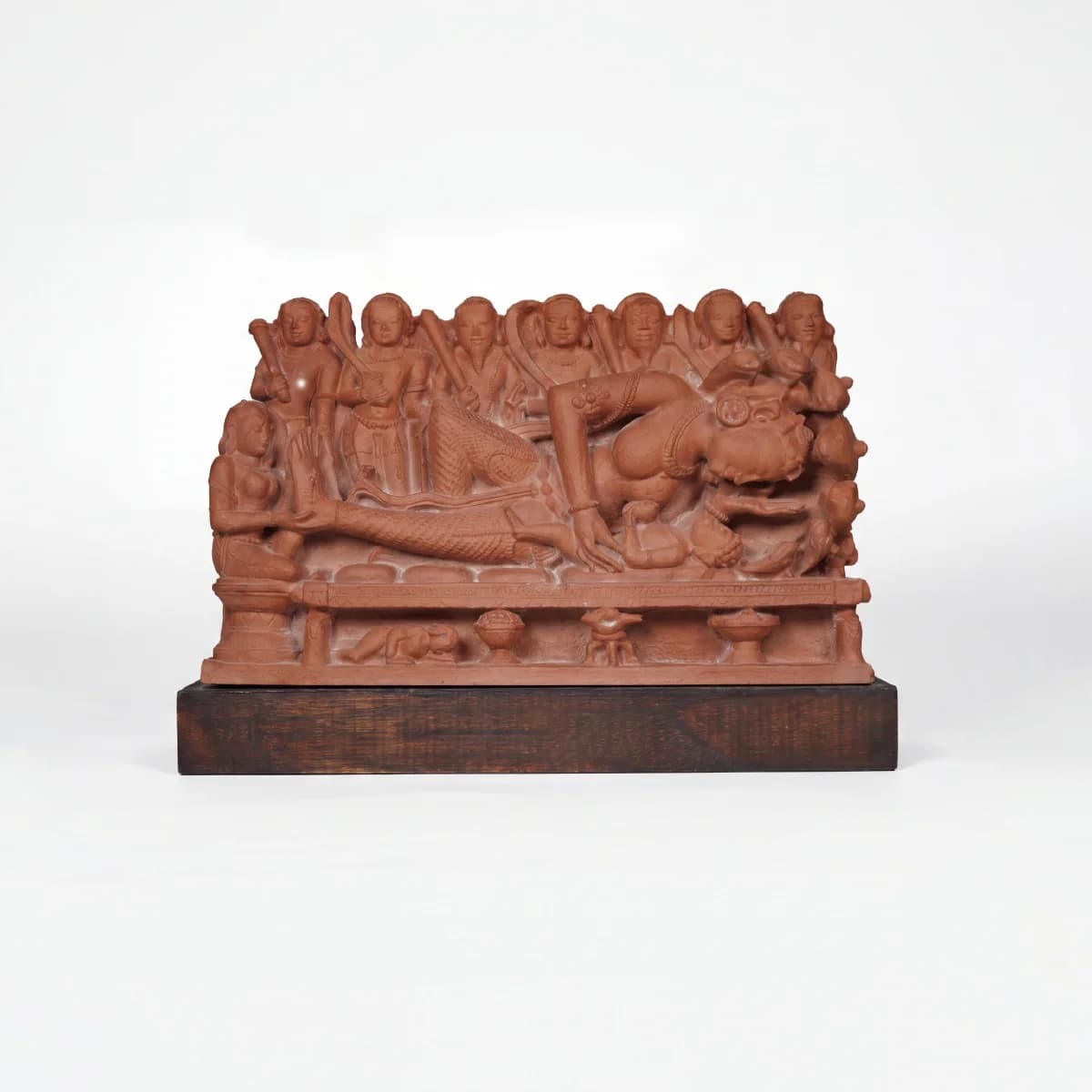 A terracotta-toned Krishna's Birth Sculpture replica featuring intricate figures of Devaki and guards on a dark wooden base.