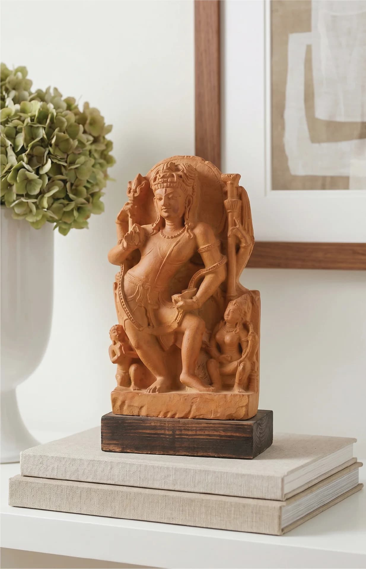 A stone composite Natesh Shiva Sculpture replica displayed on stacked books, showcasing intricate 8th-century Pratihara style craftsmanship.
