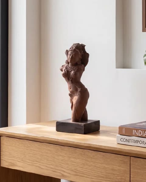 A Salabhanjika Sculpture replica in stone composite displayed on a wooden base, captured in a three-quarter angle on a desk.