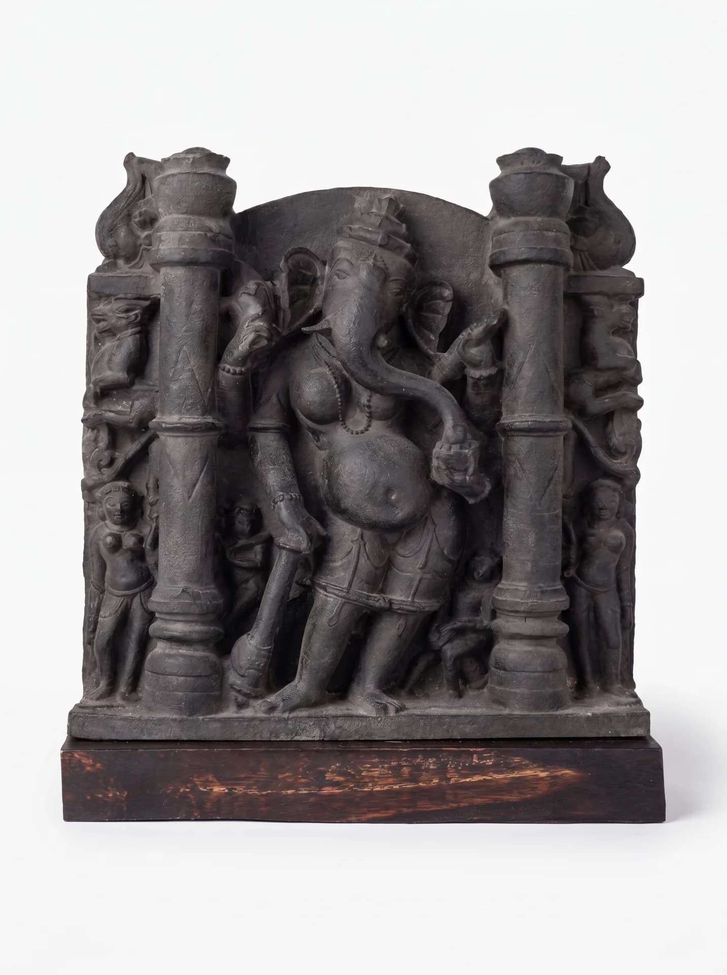 A museum-grade Vinayaki Sculpture replica featuring intricate stone-carved details of the elephant-headed deity standing between two ornate pillars.