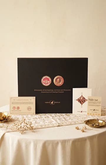 The premium display box and certificate of authenticity for the Vinayaki Sculpture, showcasing museum-grade heritage packaging on a table.