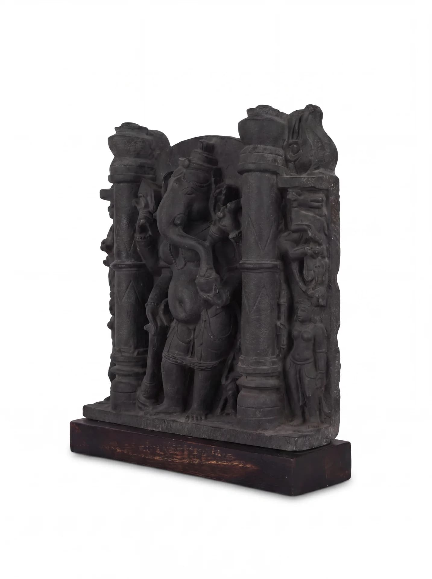 A three-quarter view of the Vinayaki Sculpture, a dark stone-finish museum replica featuring intricate temple carvings and architectural pillars.