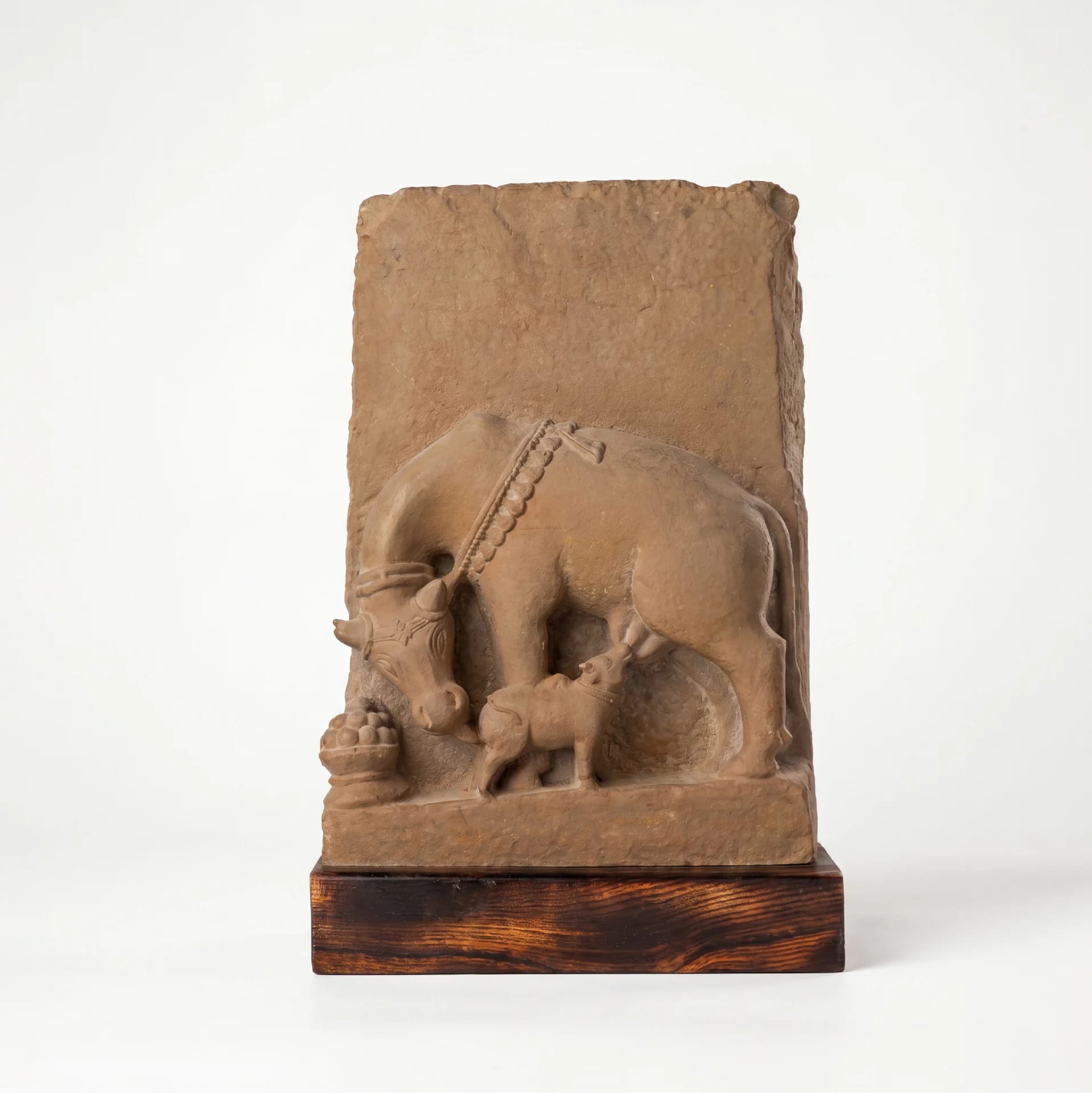 A front-facing view of the Kamdhenu Sculpture, a hand-finished stone composite replica depicting a cow nursing her calf.