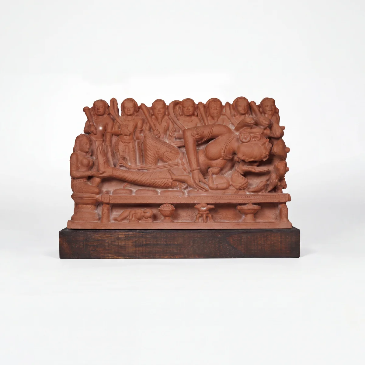 A terracotta-toned Krishna's Birth Sculpture replica featuring intricate figures of Devaki and guards on a dark wooden base.
