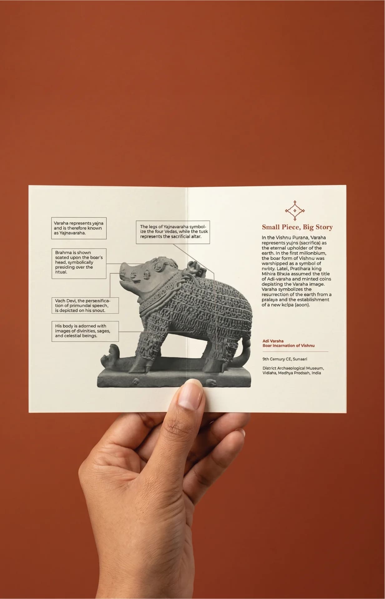 A hand holds an informational card featuring an Adi Varaha Sculpture replica with detailed annotations explaining the historical significance.