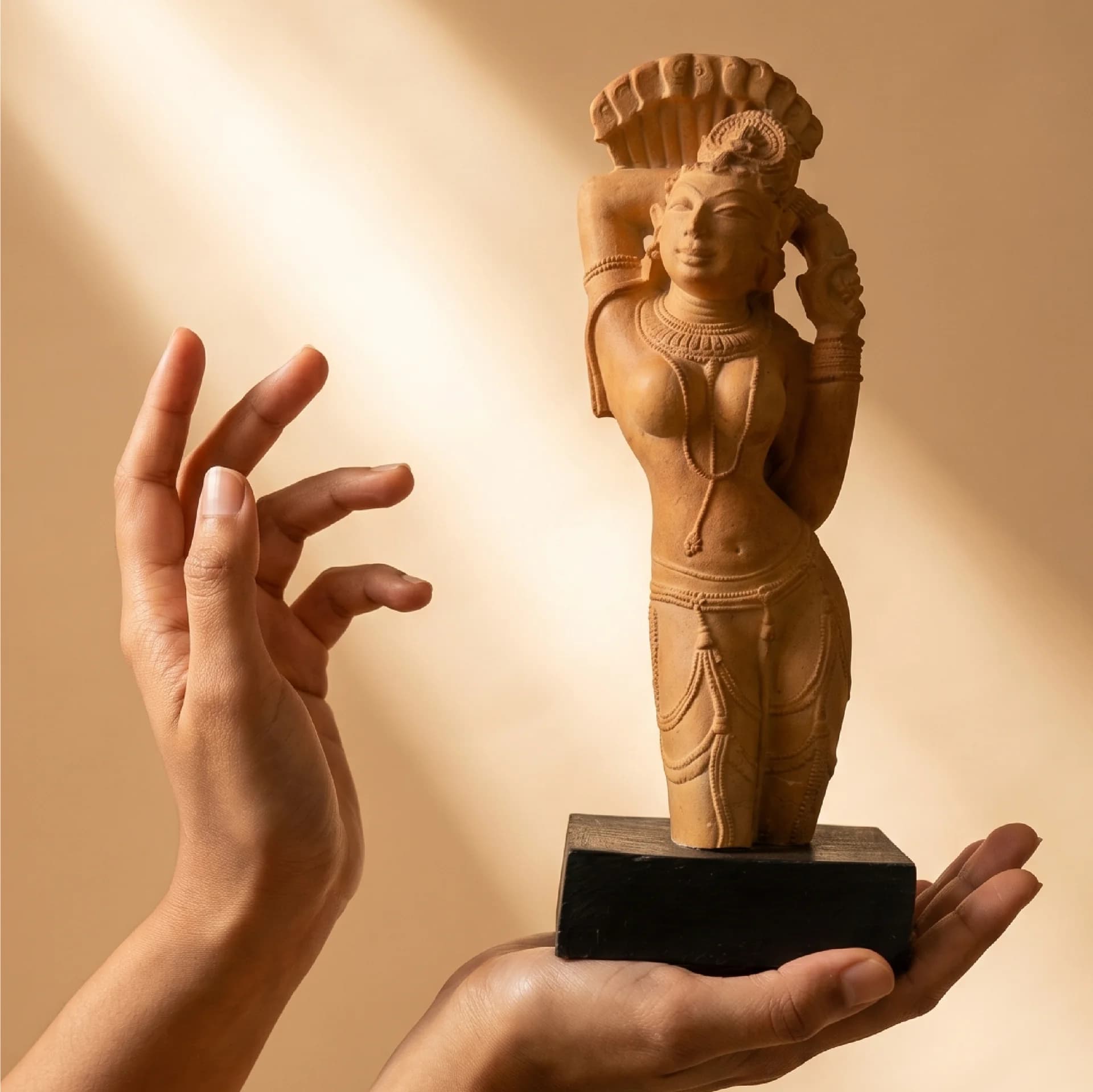 Hands gently cradle the Alasa Nayika Sculpture, a sandstone-finish replica showcasing intricate 10th-century Indian temple art details.