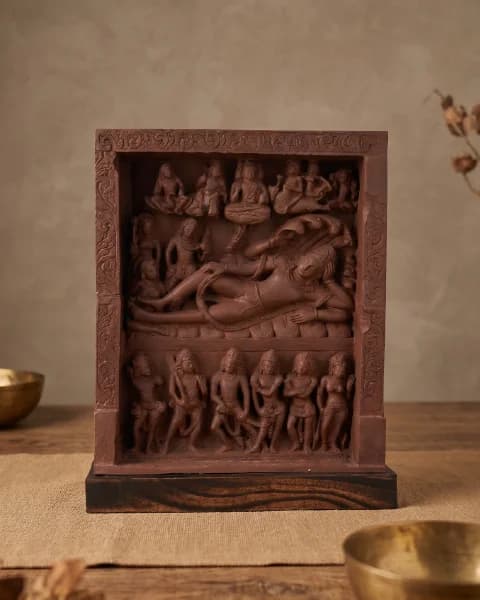 A front-facing view of the Anantasayana Vishnu Sculpture, a terracotta-style replica showing the deity reclining on a cosmic serpent.