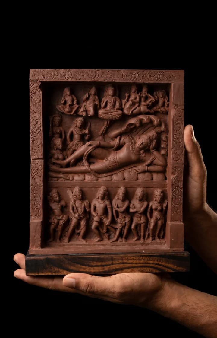 A person holds an Anantasayana Vishnu Sculpture, a detailed terracotta-style relief panel depicting the deity reclining on a serpent.