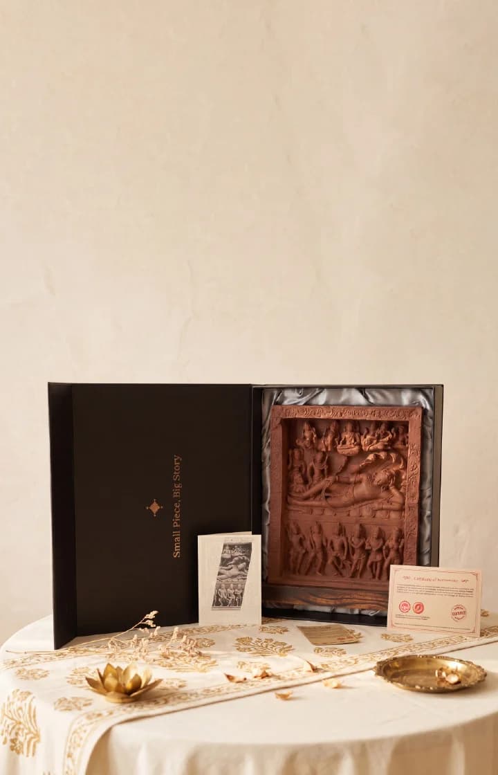 An Anantasayana Vishnu Sculpture replica presented in a black gift box with an authenticity card on a table.