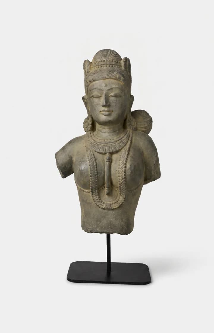 A front view of the Female Figure Bust Sculpture, a stone composite replica showcasing intricate Chola style jewelry and serene facial features.