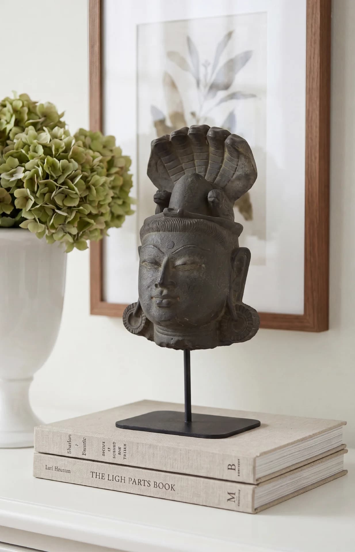 A front-facing view of the Shiva Lingam with Nandi & Serpent replica, featuring a serene stone composite head on a stand.