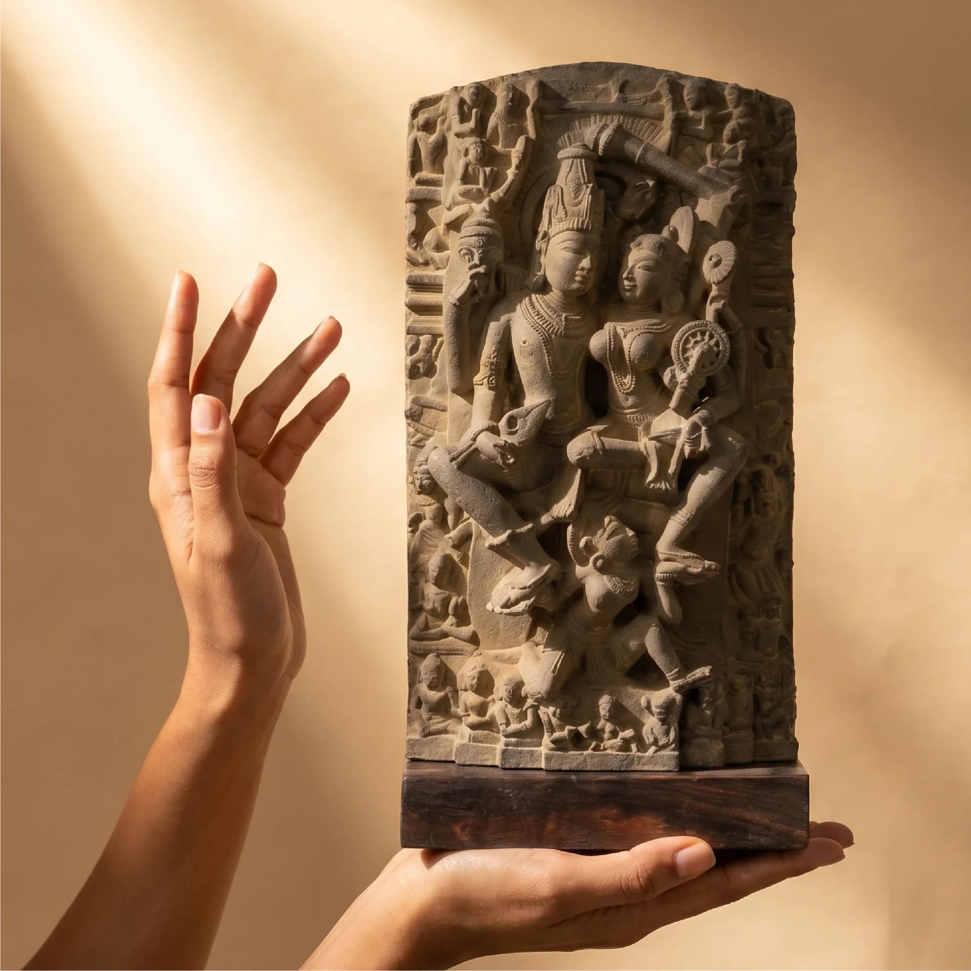 A person holds a detailed Lakshmi Narayan Sculpture, a stone museum-replica showing intricate 12th-century carvings against a warm background.
