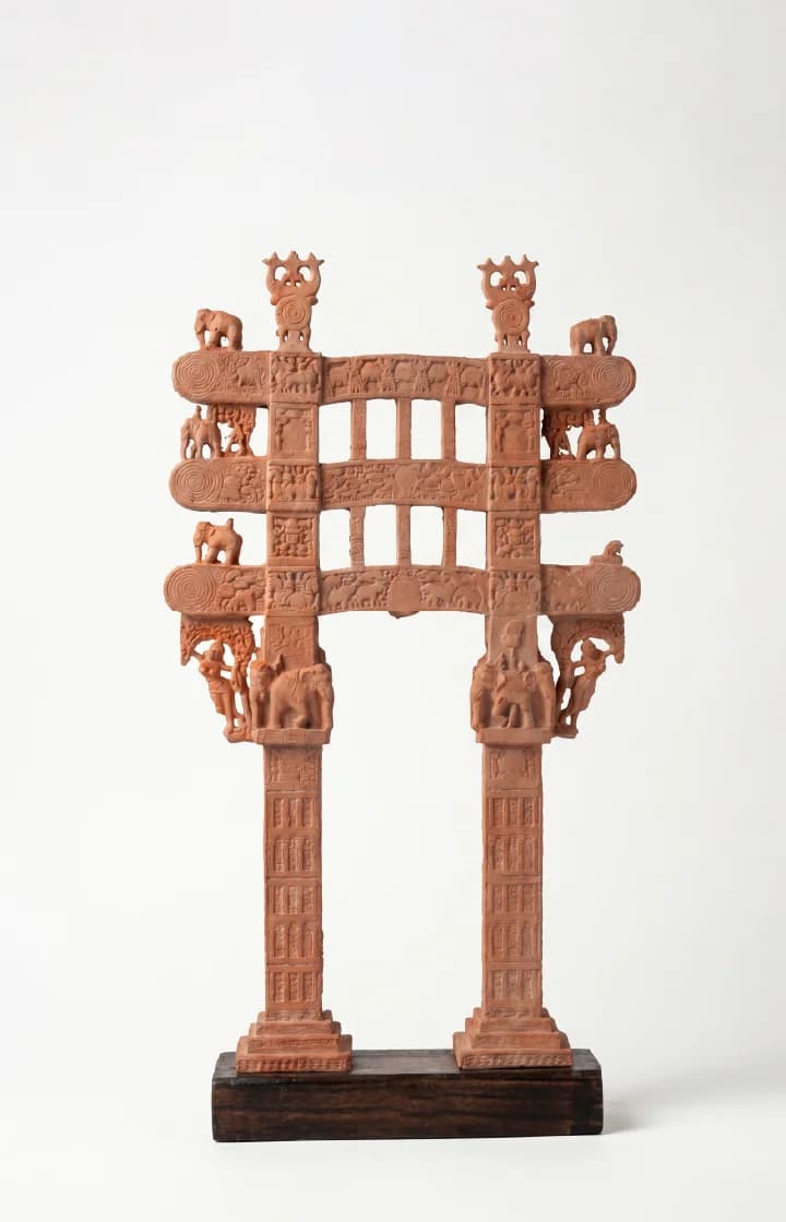 A front-facing view of the Sanchi Torana Gateway Miniature, a detailed stone composite replica featuring intricate carvings of elephants and figures.
