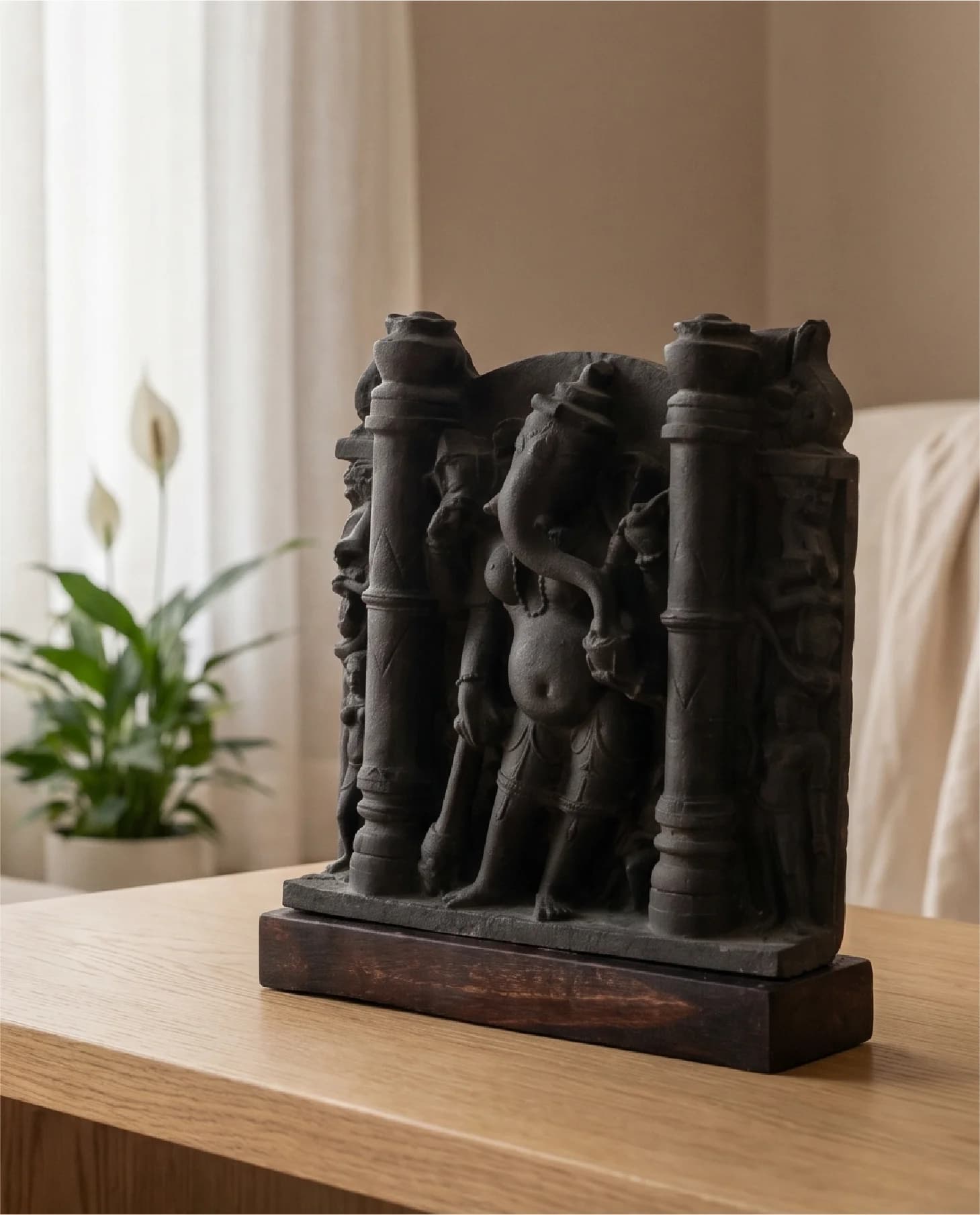 A three-quarter view of the Vinayaki Sculpture, a dark stone-finish museum replica standing on a wooden base.